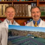 doctors posing with photo of rooftop solar panels